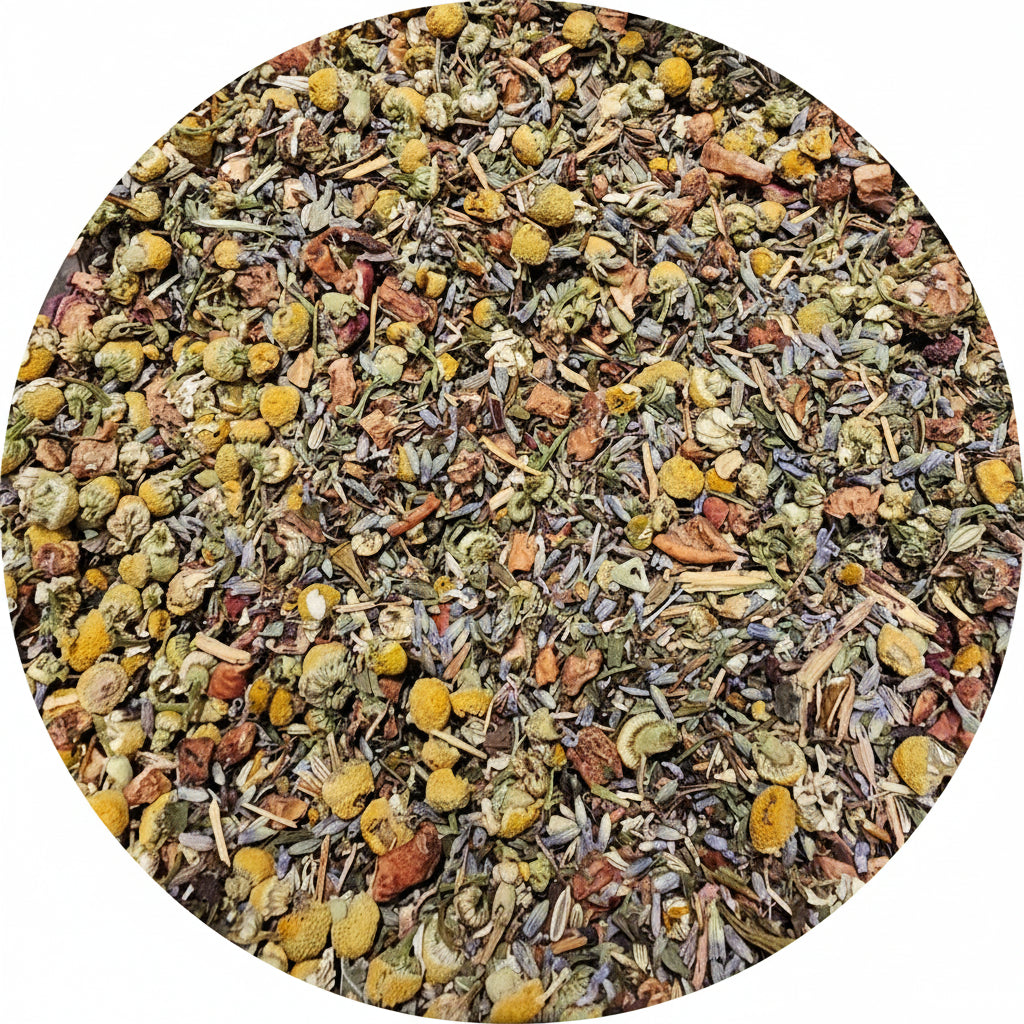 A close-up top-down view of loose-leaf herbal tea mixed inside a large stainless steel bowl. The tea contains dried yellow flowers, green leaves, and small orange-brown pieces.